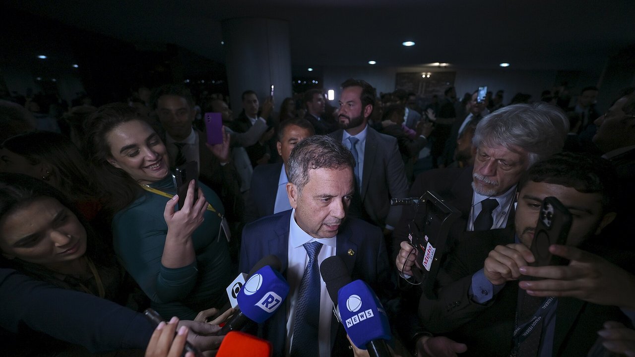Senador Rogério Marinho fala com jornalistas em entrevista coletiva, cercado de microfones